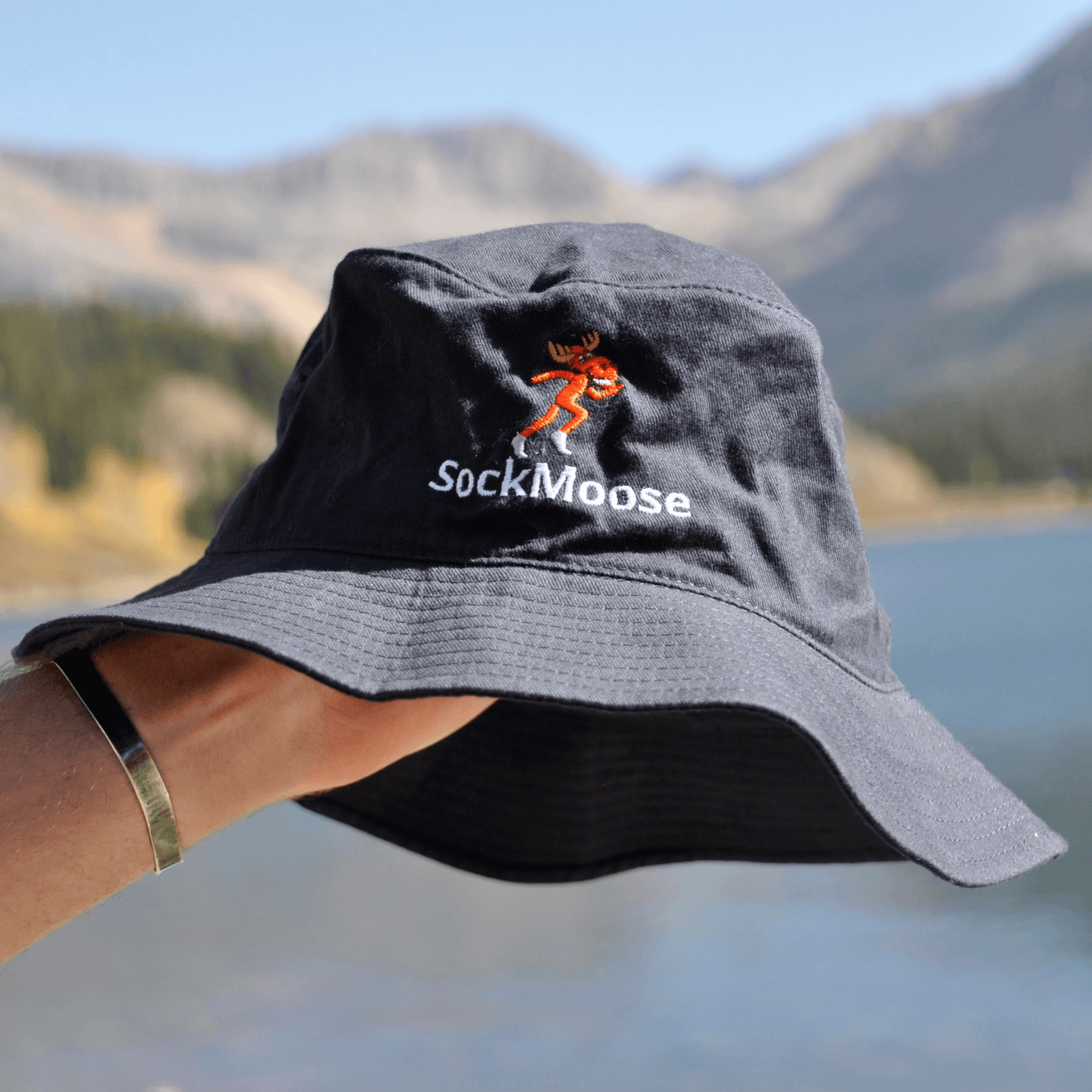 SockMoose running socks black bucket hat with cartoon moose logo with mountain background