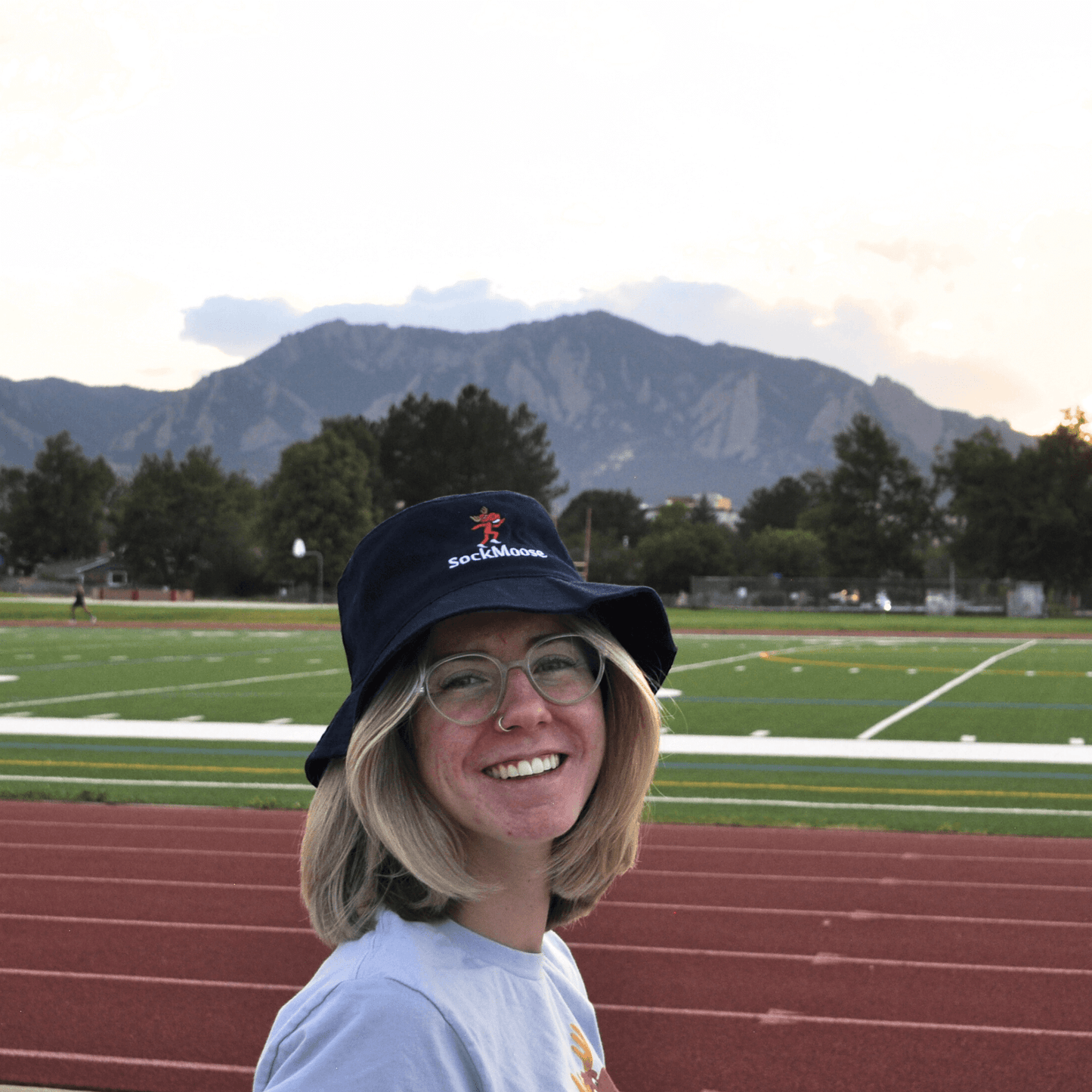 Female runner wearing SockMoose running socks navy blue bucket hat with cartoon moose logo