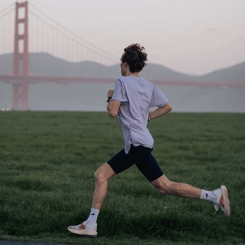 Male runner running in SockMoose high performance running socks with Golden Gate Bridge in the background.