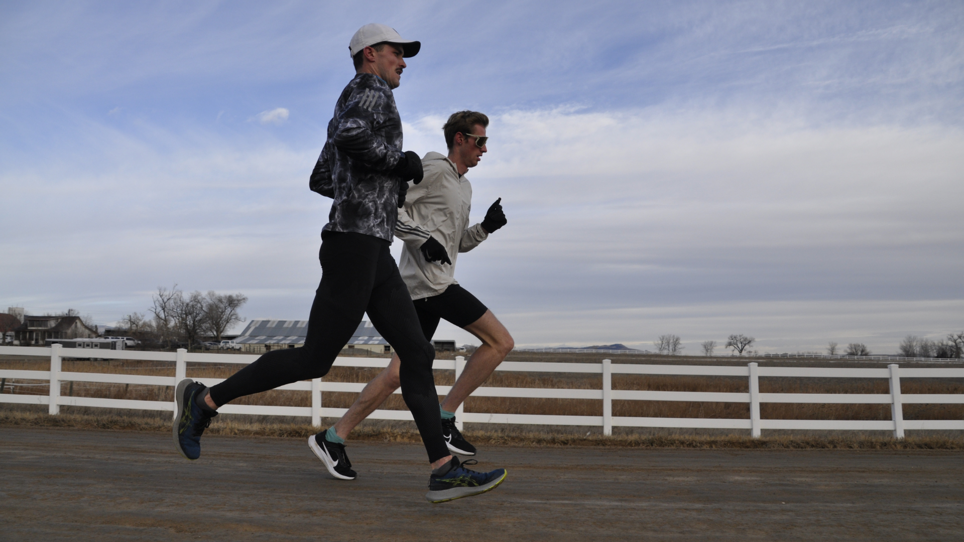 Two male runners wearing the best running socks, running on dirt road