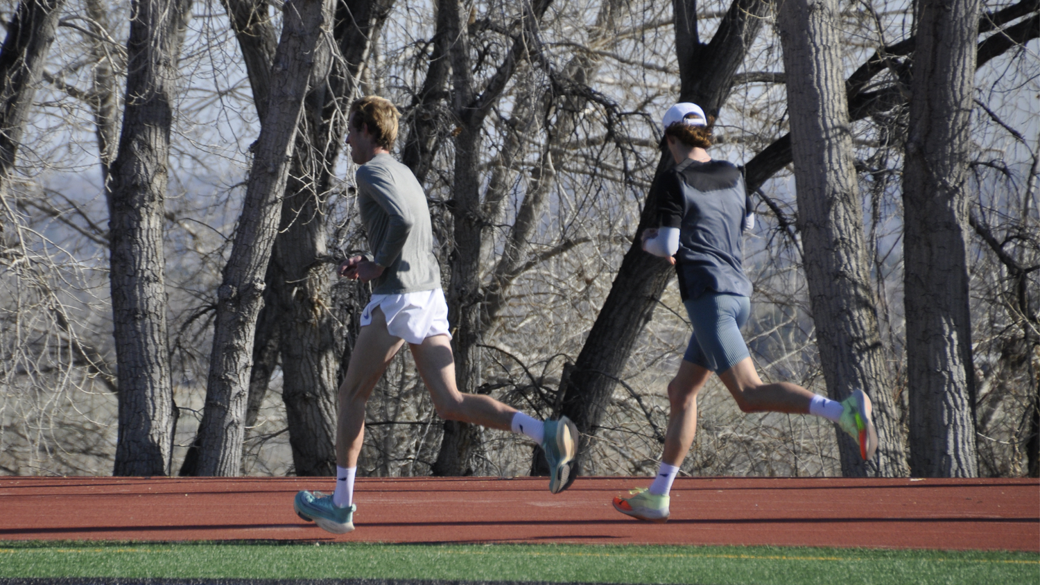 Two runners on a track wearing sockmoose high performance running socks, the best running socks