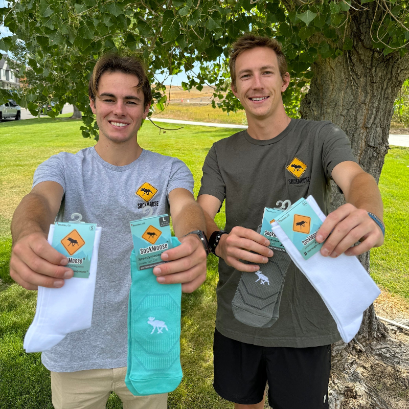 SockMoose running socks founders Hunter Appleton and Cayce Reese holding SockMoose running socks.